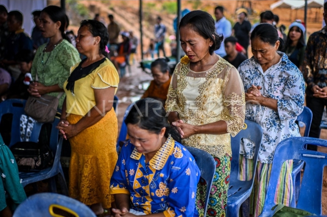 Masyarakat sedang berdoa bersama saat perayaan Natal di kamp pengungsian bencana di Sumatera.